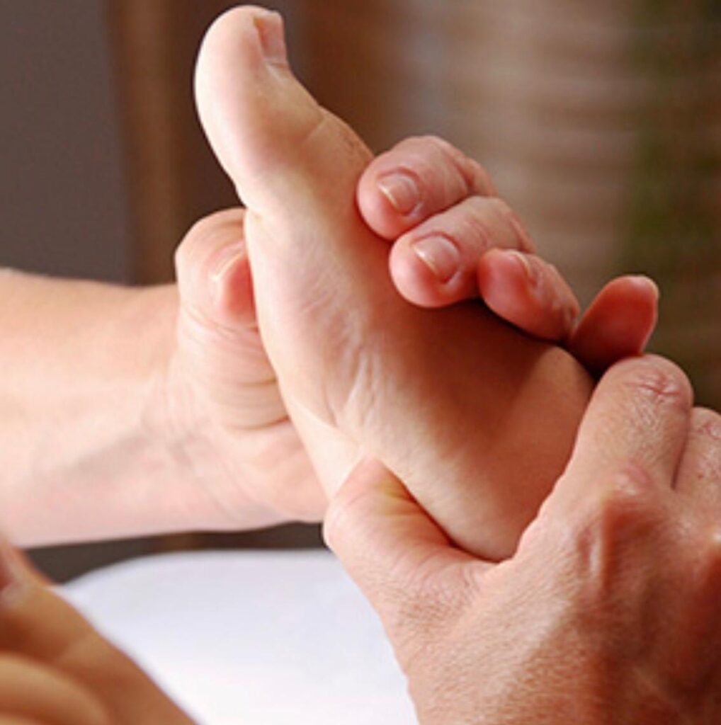 Detailaufnahme einer Fussreflexzonen-Massage mit gezielten Druckpunkten an der Fusssohle.