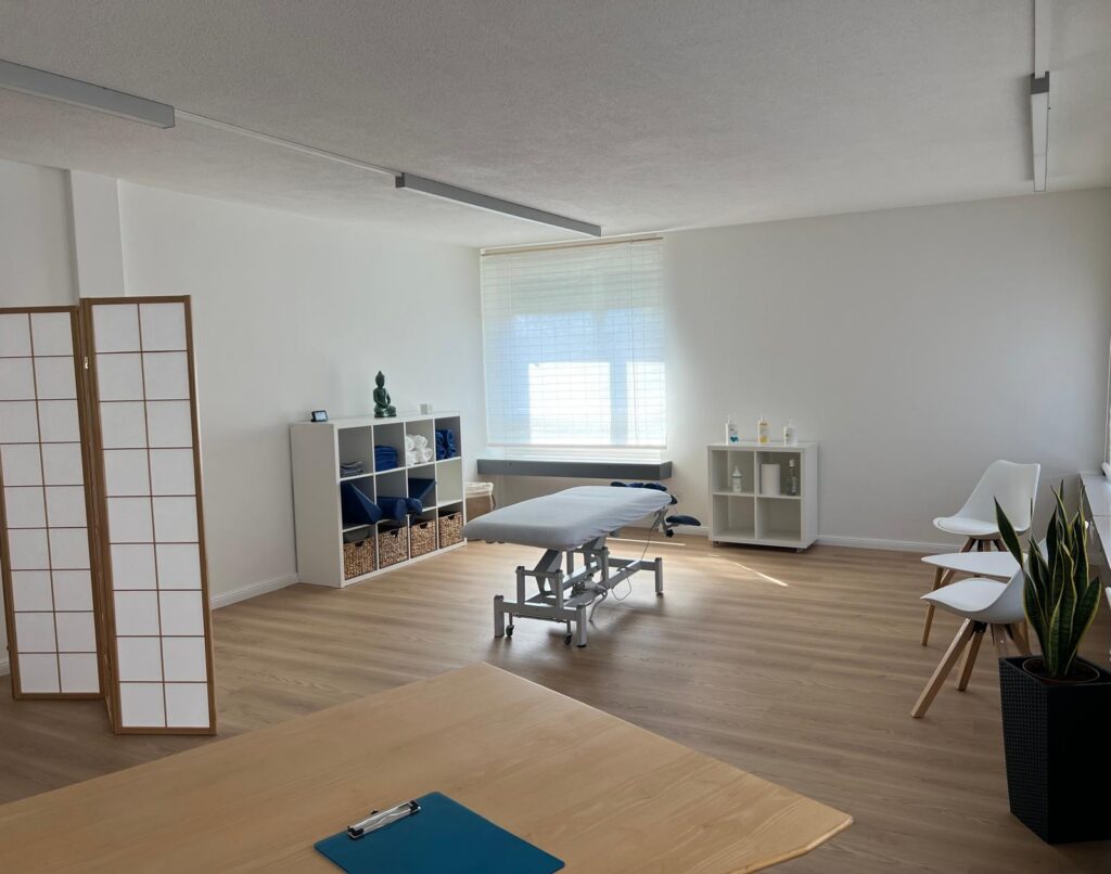 Ruhige Massagepraxis mit warmem Licht und sanften Naturtönen als Willkommensszene.